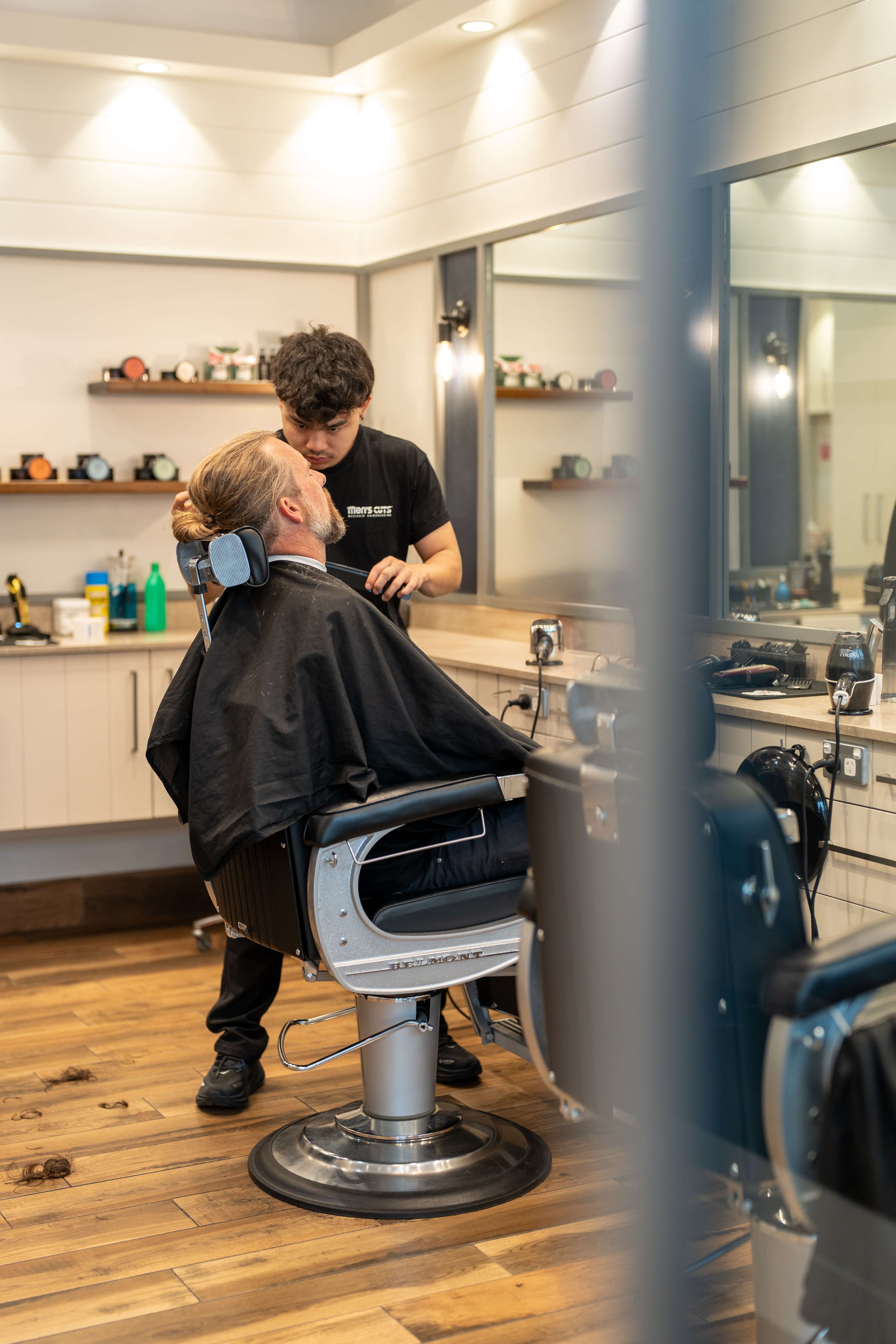 Men's Cuts barber working on a client's beard