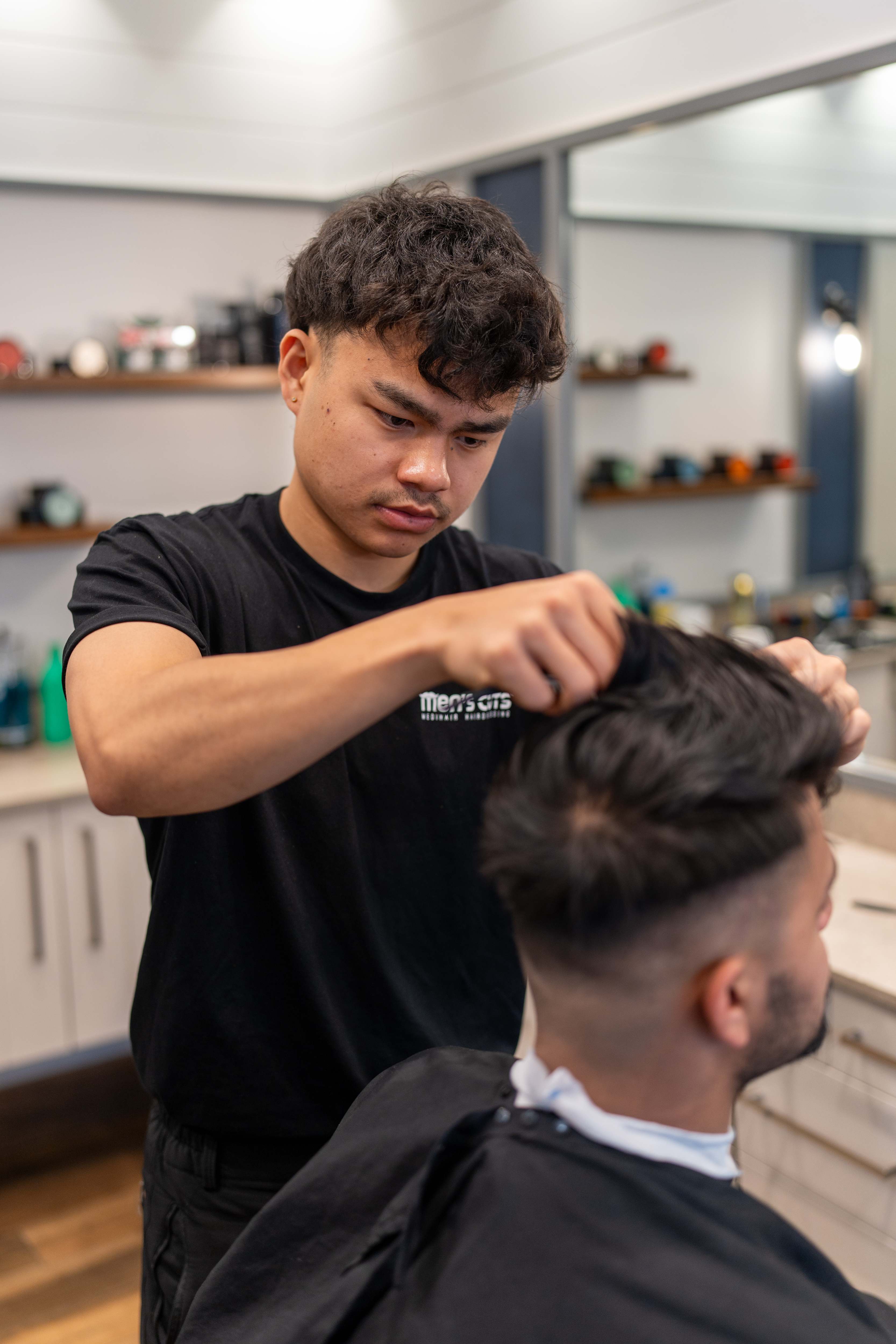 Men's Cuts barber styling a client's hair